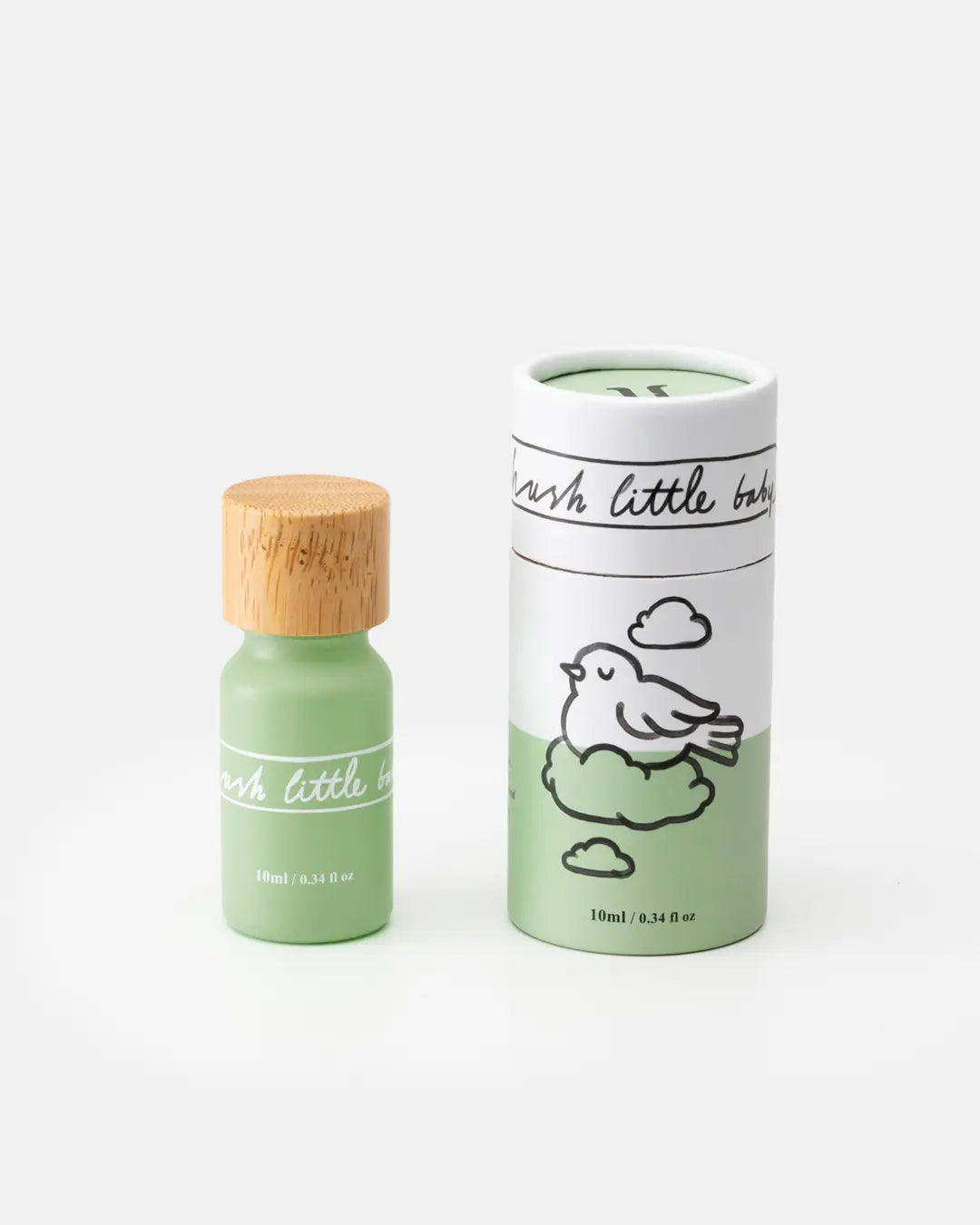 Natürliches Duftöl in mintgrüner Glasflasche mit Holzdeckel, daneben zylindrische Verpackung mit Vogel auf Wolke