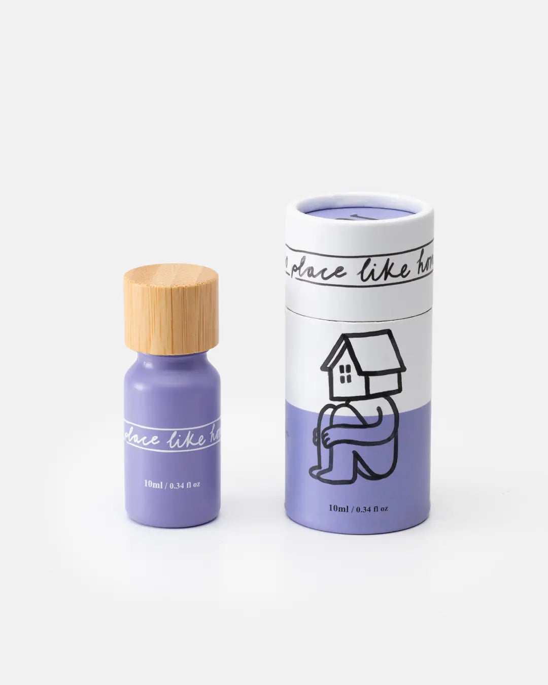 Natürliches Duftöl 10 ml in lilafarbener Glasflasche mit hellem Holzdeckel neben passender lilaweißer Kartonverpackung