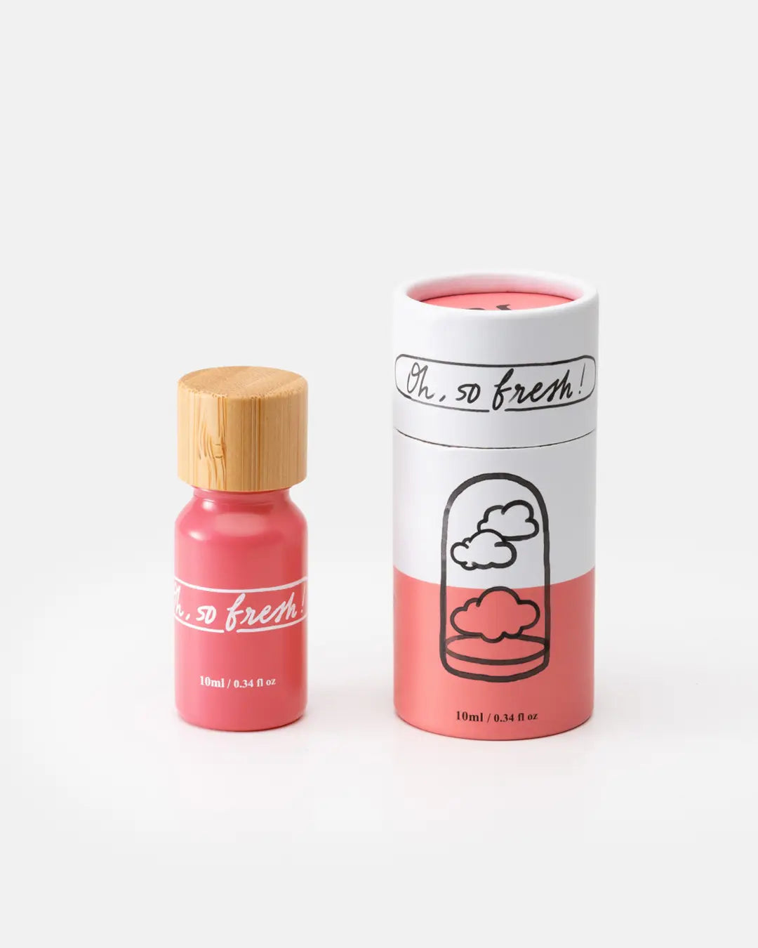 Natürliches Duftöl in rosa Flasche mit Holzdeckel neben passender rosa‑weißer Kartonverpackung mit Wolkenillustration